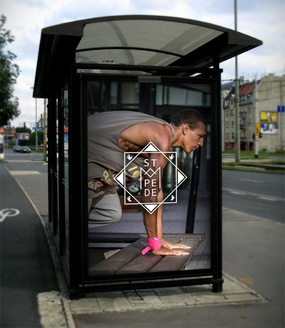 A bus shelter by a street, with an advert where a person in a starting position stands behind the logo in white.